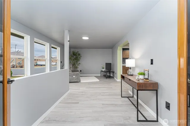 a living room with furniture and a potted plant next to a window