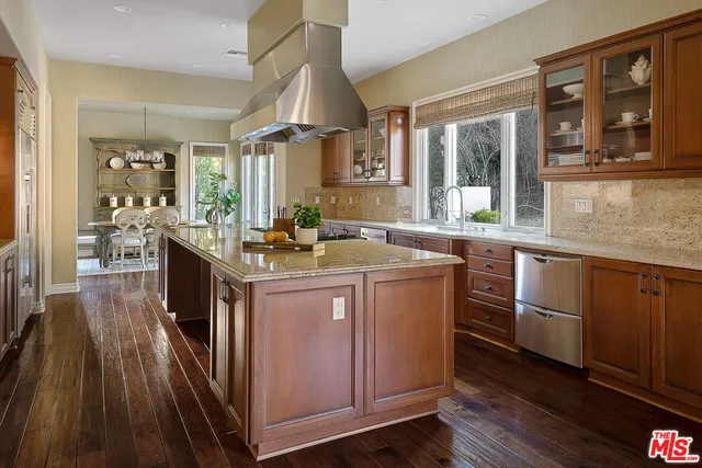 a kitchen with kitchen island granite countertop wooden floors and stainless steel appliances