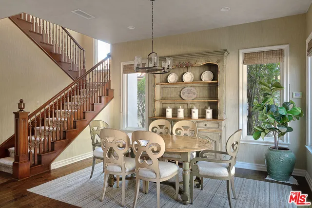 a view of a dining room and livingroom with furniture wooden floor a chandelier