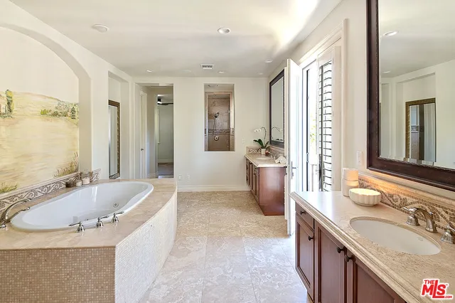 a spacious bathroom with a tub sink shower and mirror