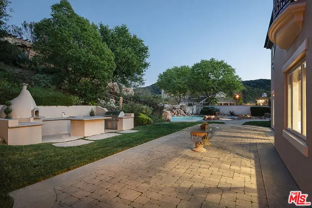 a view of a patio with a table and chairs under an umbrella