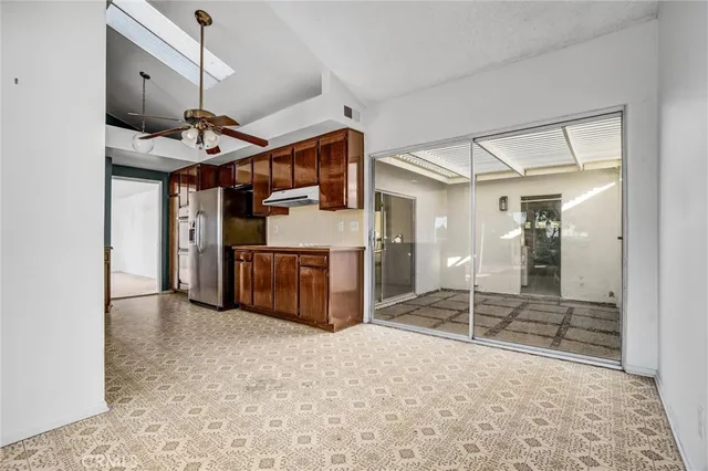 a kitchen with a sink appliances cabinets and a large window