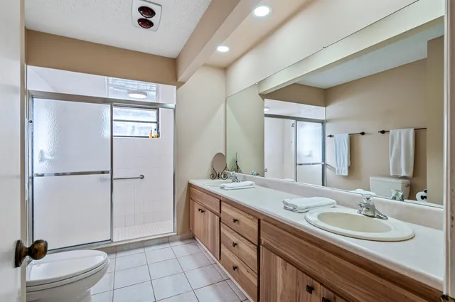 a spacious bathroom with a double vanity sink toilet mirror and double