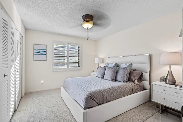 a large bed sitting in a bedroom next to a window and a lamp