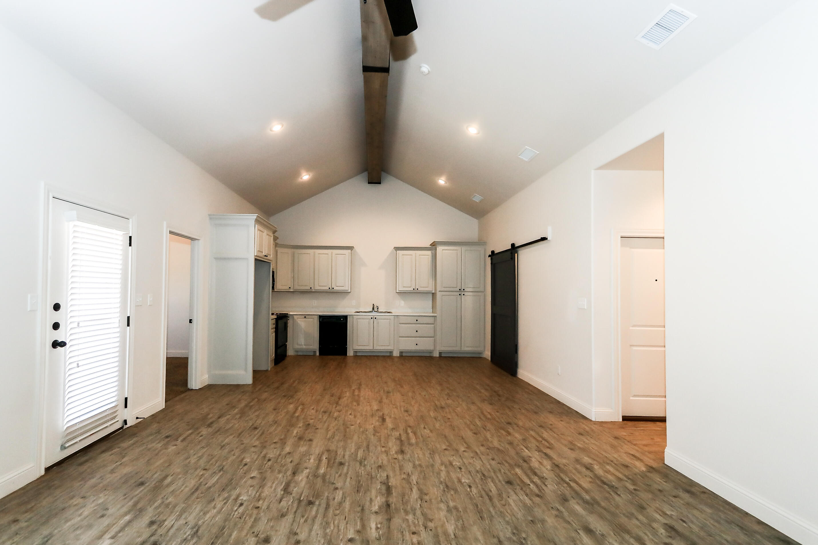 2518 B 111th Street Lubbock, TX 79423 - Photo 6 of 23 an empty room with wooden floor and a ceiling fan