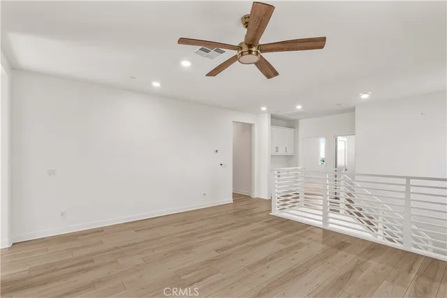 a view of a big room with wooden floor and windows