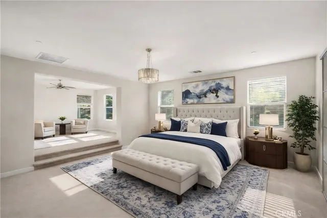 a bedroom with a large bed and a chandelier