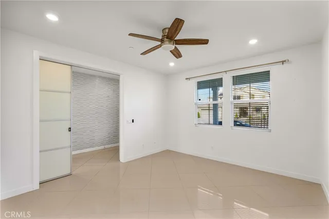 an empty room with window and ceiling fan