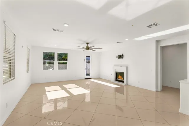 an empty room with windows and fireplace