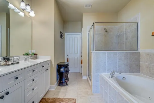 a bathroom with a tub a sink and a large mirror
