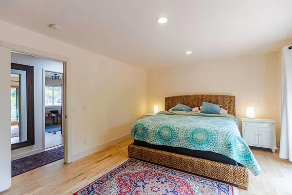 a bedroom with a bed and wooden floor