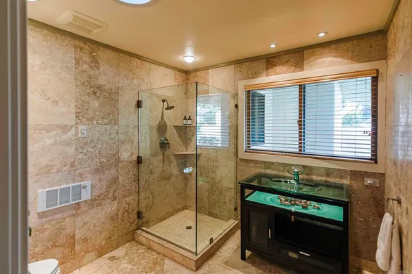 a bathroom with a granite countertop sink a toilet and shower