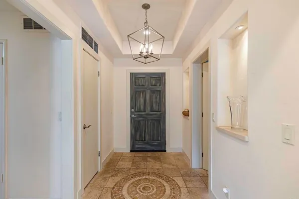 a view of a hallway with wooden floor and chandelier