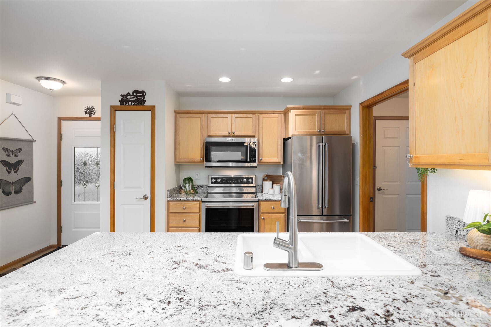 1182 Decatur Circle, Unit 7A Burlington, WA 98233 - Photo 11 of 36 a kitchen with stainless steel appliances kitchen island granite countertop a refrigerator and a stove top oven
