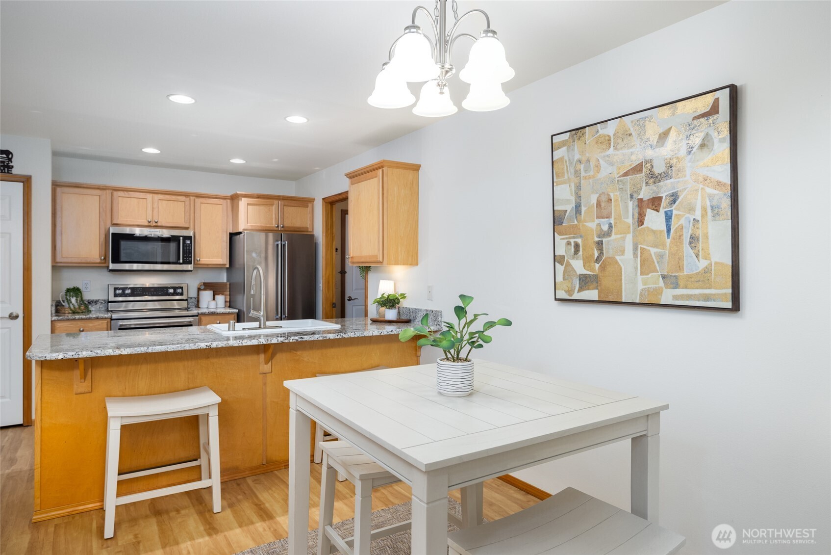 1182 Decatur Circle, Unit 7A Burlington, WA 98233 - Photo 12 of 36 a kitchen with stainless steel appliances kitchen island granite countertop a refrigerator a stove top oven a sink dishwasher and white cabinets with wooden floor