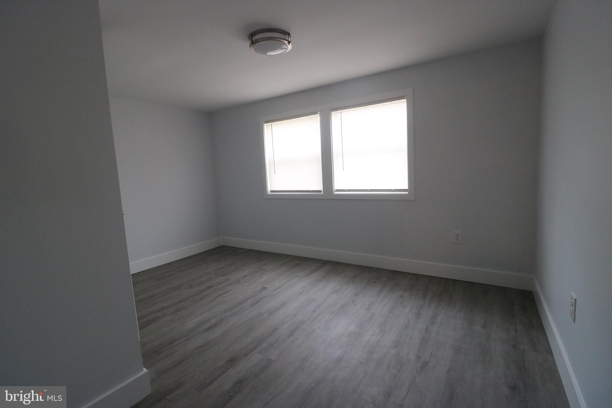 121 Bengies Road Middle River, MD 21220 - Photo 3 of 6 an empty room with wooden floor and windows