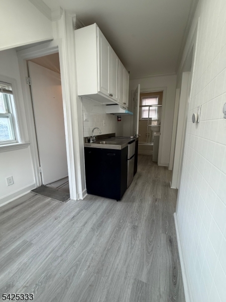 124 Stone Street, Unit 3 Newark, NJ 07104 - Photo 4 of 10 a kitchen with granite countertop a stove top oven a sink and a refrigerator