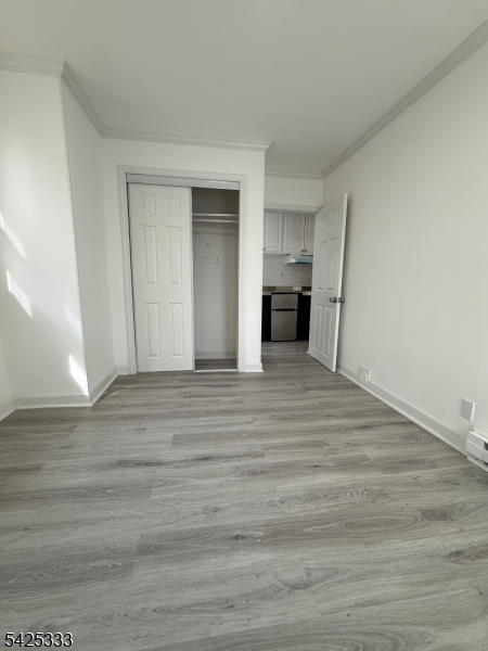 124 Stone Street, Unit 3 Newark, NJ 07104 - Photo 6 of 10 a view of a kitchen and empty room with wooden floor