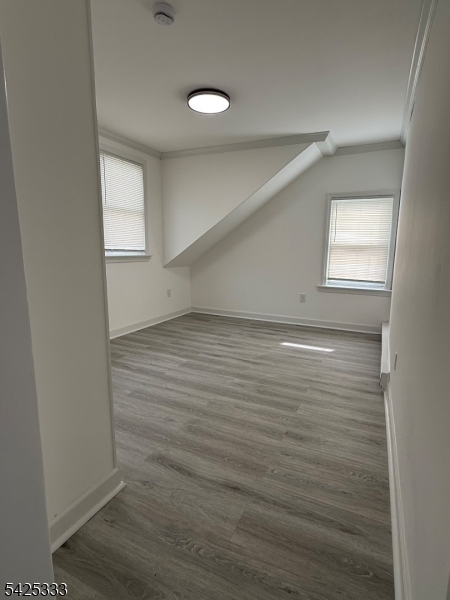 124 Stone Street, Unit 3 Newark, NJ 07104 - Photo 7 of 10 an empty room with wooden floor and windows