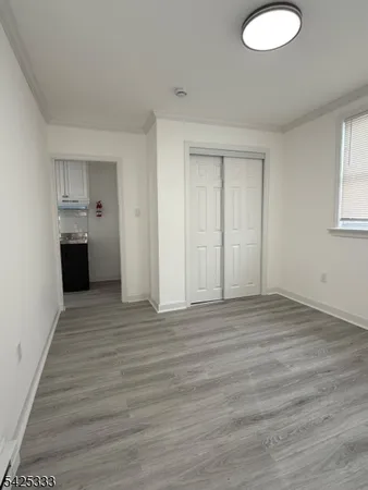 a view of empty room with wooden floor and window