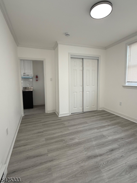 124 Stone Street, Unit 3 Newark, NJ 07104 - Photo 8 of 10 a view of empty room with wooden floor and window