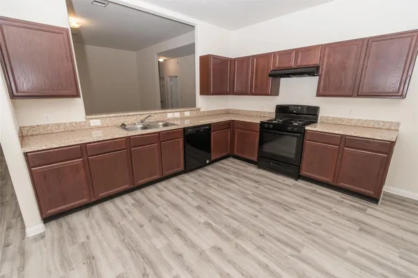 a kitchen with stainless steel appliances granite countertop a sink stove and wooden cabinets