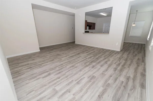 an empty room with wooden floor and mirror