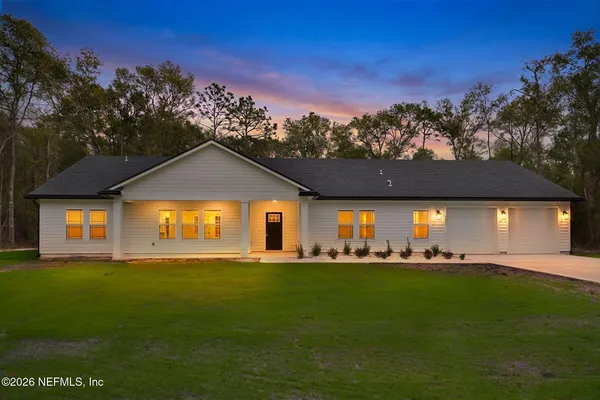 a front view of a house with a garden and yard