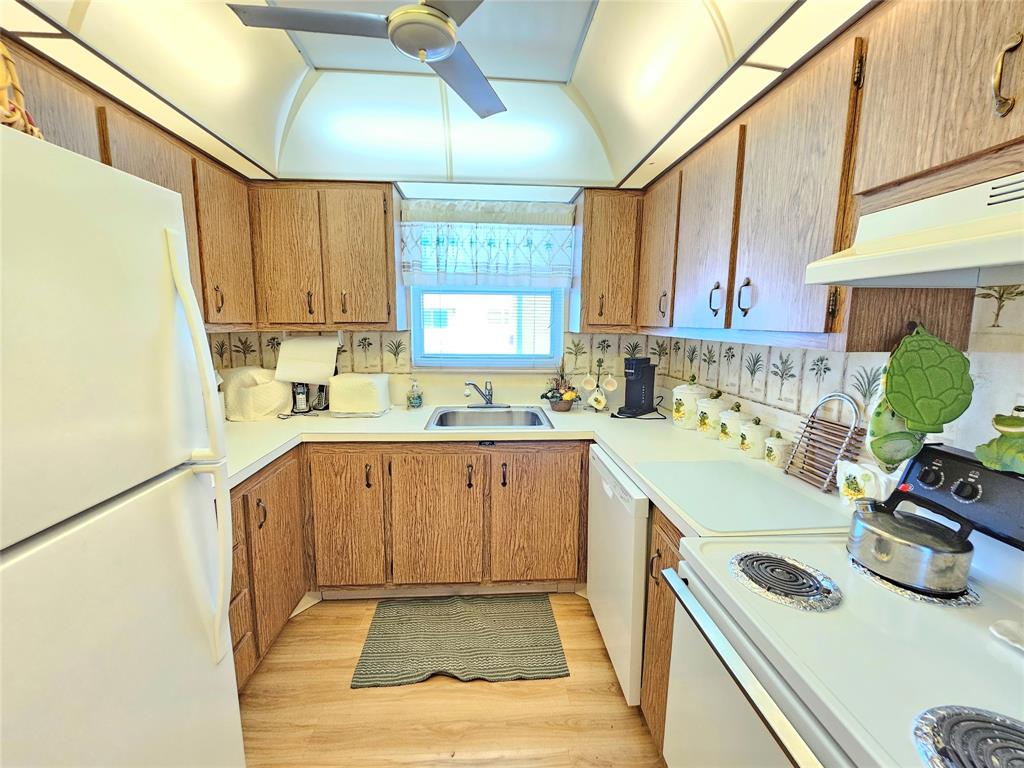 2850 Northeast 14th Street, Unit 410B Pompano Beach, FL 33062 - Photo 5 of 25 a kitchen with a sink a stove and cabinets