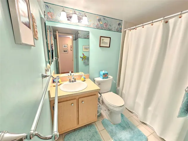 a bathroom with a sink a toilet and shower curtain