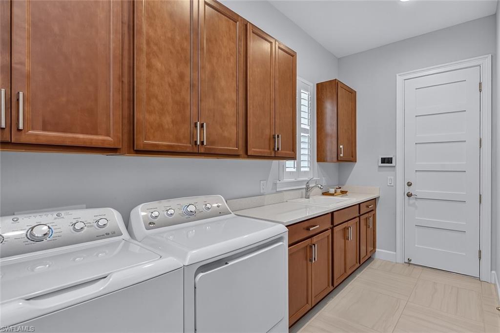 6387 Warwick Avenue Naples, FL 34113 - Photo 22 of 40 Laundry area with washer and dryer and lots of cabinet space