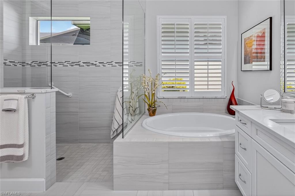 6387 Warwick Avenue Naples, FL 34113 - Photo 27 of 40 Bathroom featuring a garden tub, dual vanity, and walk in shower