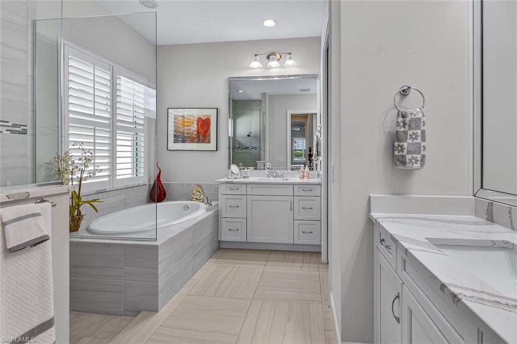 6387 Warwick Avenue Naples, FL 34113 - Photo 28 of 40 Full bath with plenty of natural light, two vanities, a garden tub, and a walk in shower