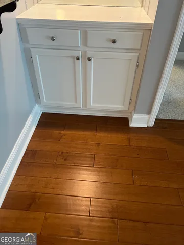 a view of a kitchen with wooden floor and cabinets