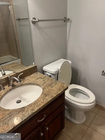 a bathroom with a granite countertop sink and washing machine