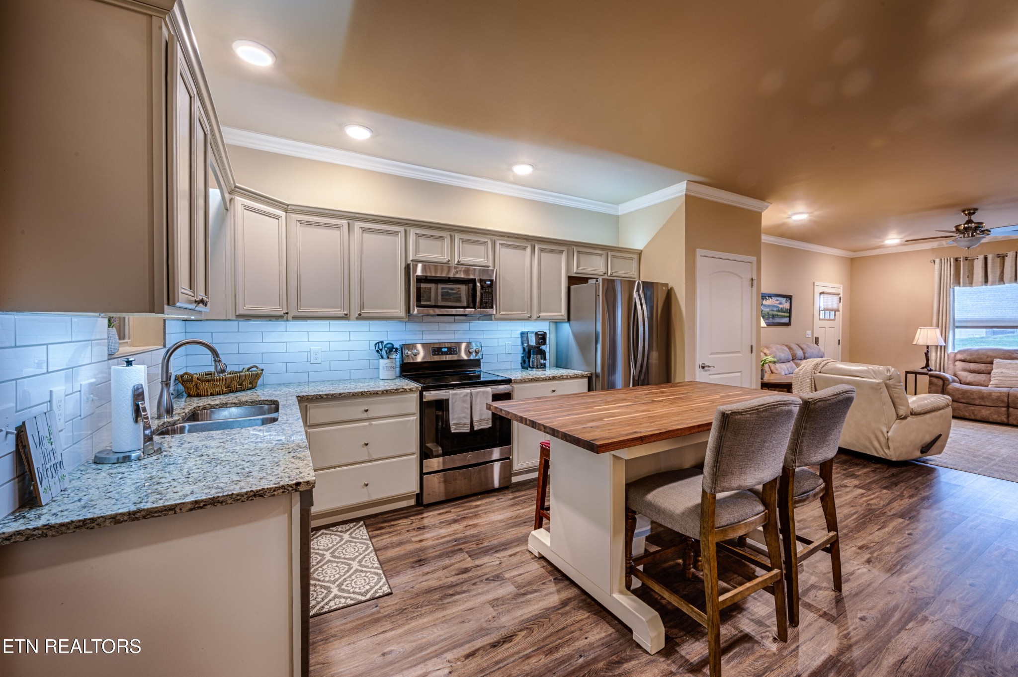 229 Bishops Cap Circle, Unit 101 Townsend, TN 37882 - Photo 15 of 47 a kitchen with kitchen island granite countertop wooden floors and stainless steel appliances