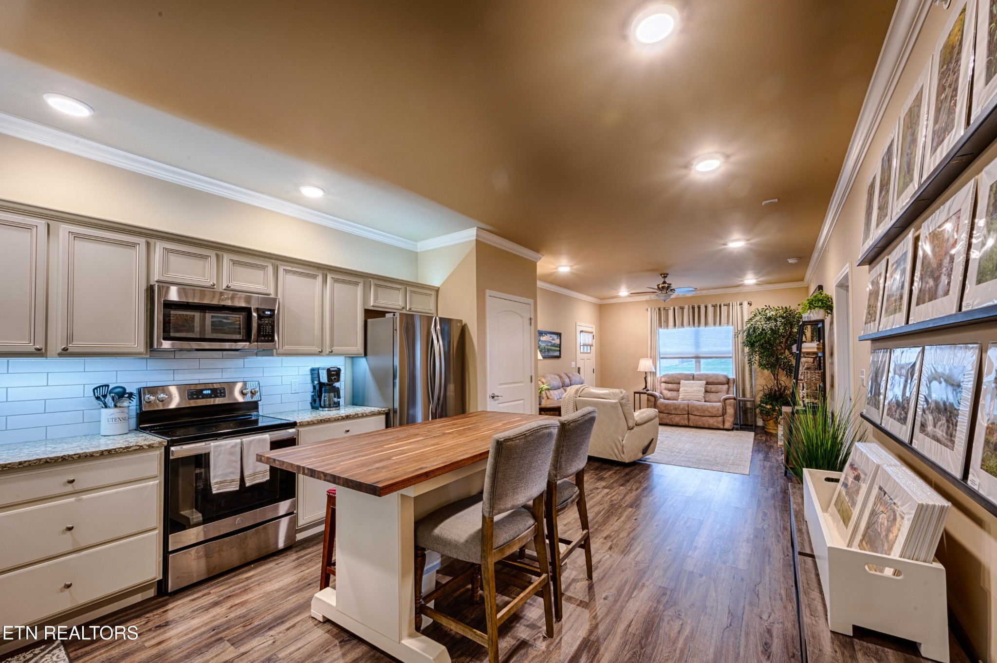 229 Bishops Cap Circle, Unit 101 Townsend, TN 37882 - Photo 16 of 47 a kitchen with stainless steel appliances kitchen island granite countertop a stove top oven a sink dishwasher a dining table and chairs with wooden floor