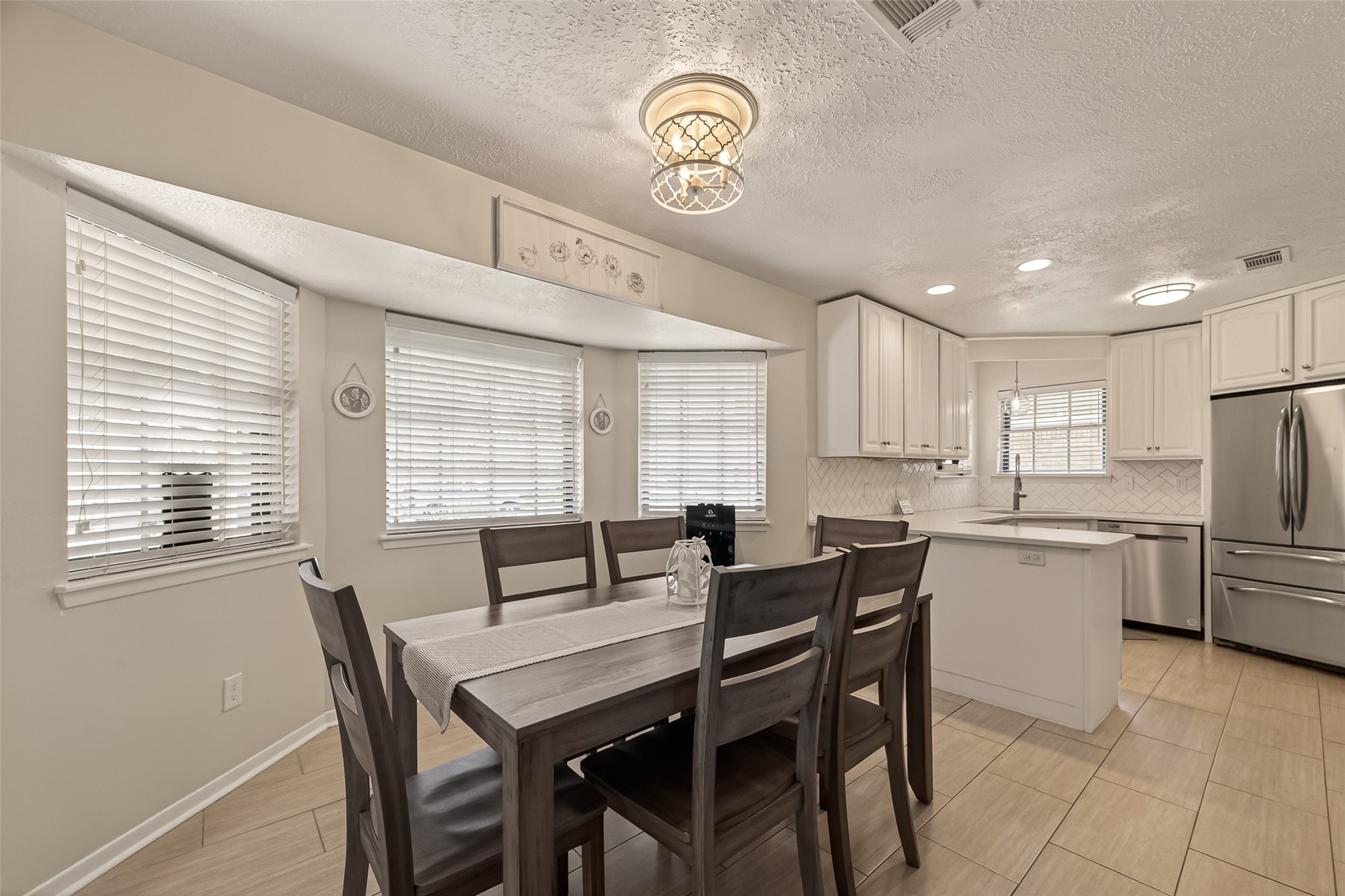 555 Shealy Street Houston, TX 77598 - Photo 11 of 41 a dining room with stainless steel appliances kitchen island granite countertop furniture and a large window