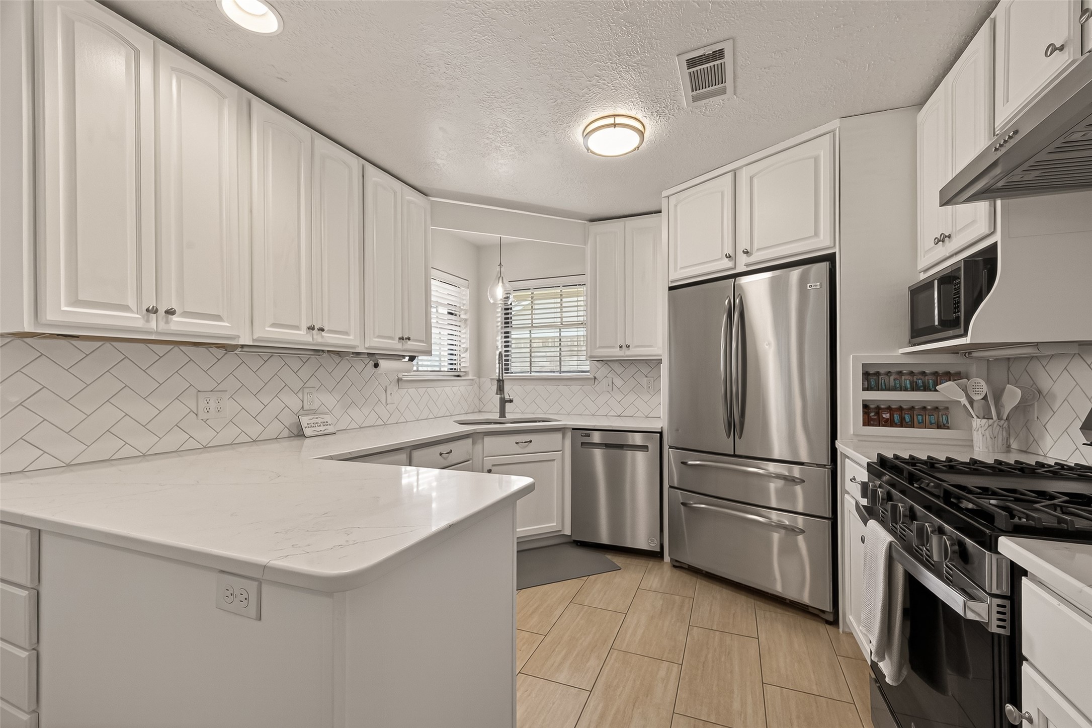 555 Shealy Street Houston, TX 77598 - Photo 13 of 41 a kitchen with a sink a refrigerator and white cabinets