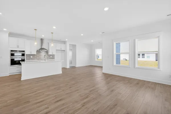 a large kitchen with stainless steel appliances a large counter top a sink a refrigerator and a window