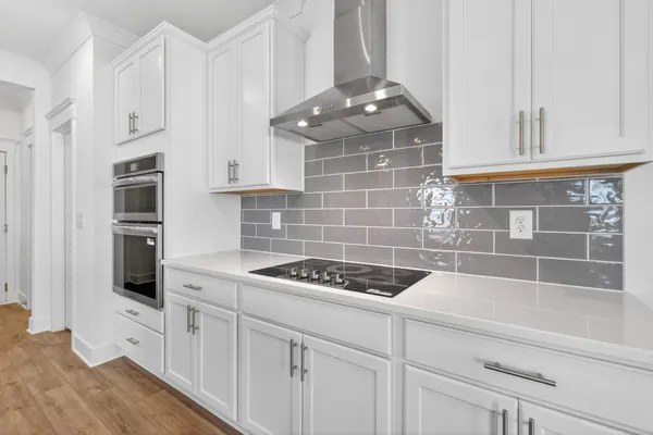a large kitchen with granite countertop a white center island stainless steel appliances and cabinets