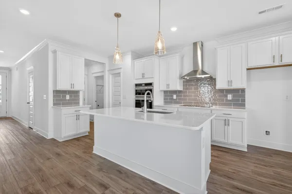 a view of a kitchen with wooden floor and a window