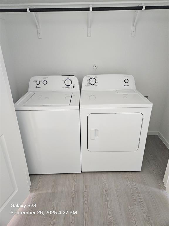 1021 Raintree Road Princeton, TX 75407 - Photo 16 of 16 Laundry area with light wood-style flooring and independent washer and dryer