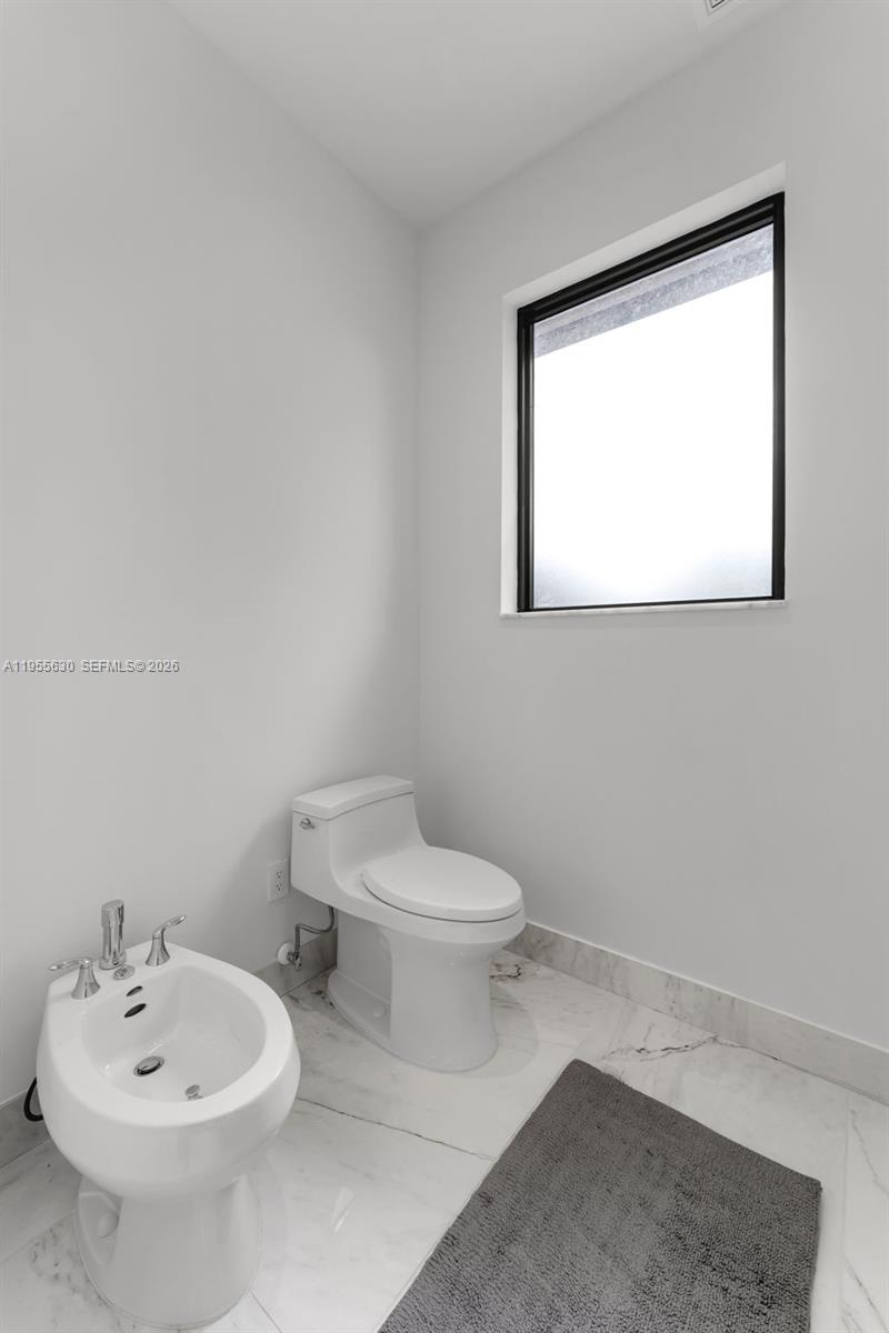 4950 Southwest 158th Ave Ranches Southwest Ranches, FL 33331 - Photo 40 of 75 a white toilet sitting next to a bathroom sink