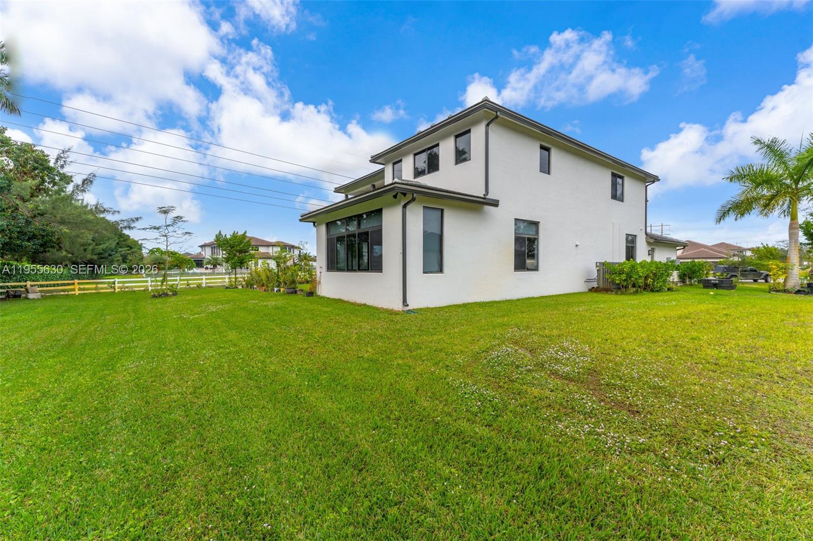 4950 Southwest 158th Ave Ranches Southwest Ranches, FL 33331 - Photo 62 of 75 a view of a white house with a big yard and potted plants