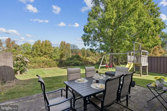 a backyard of a house with table and chairs