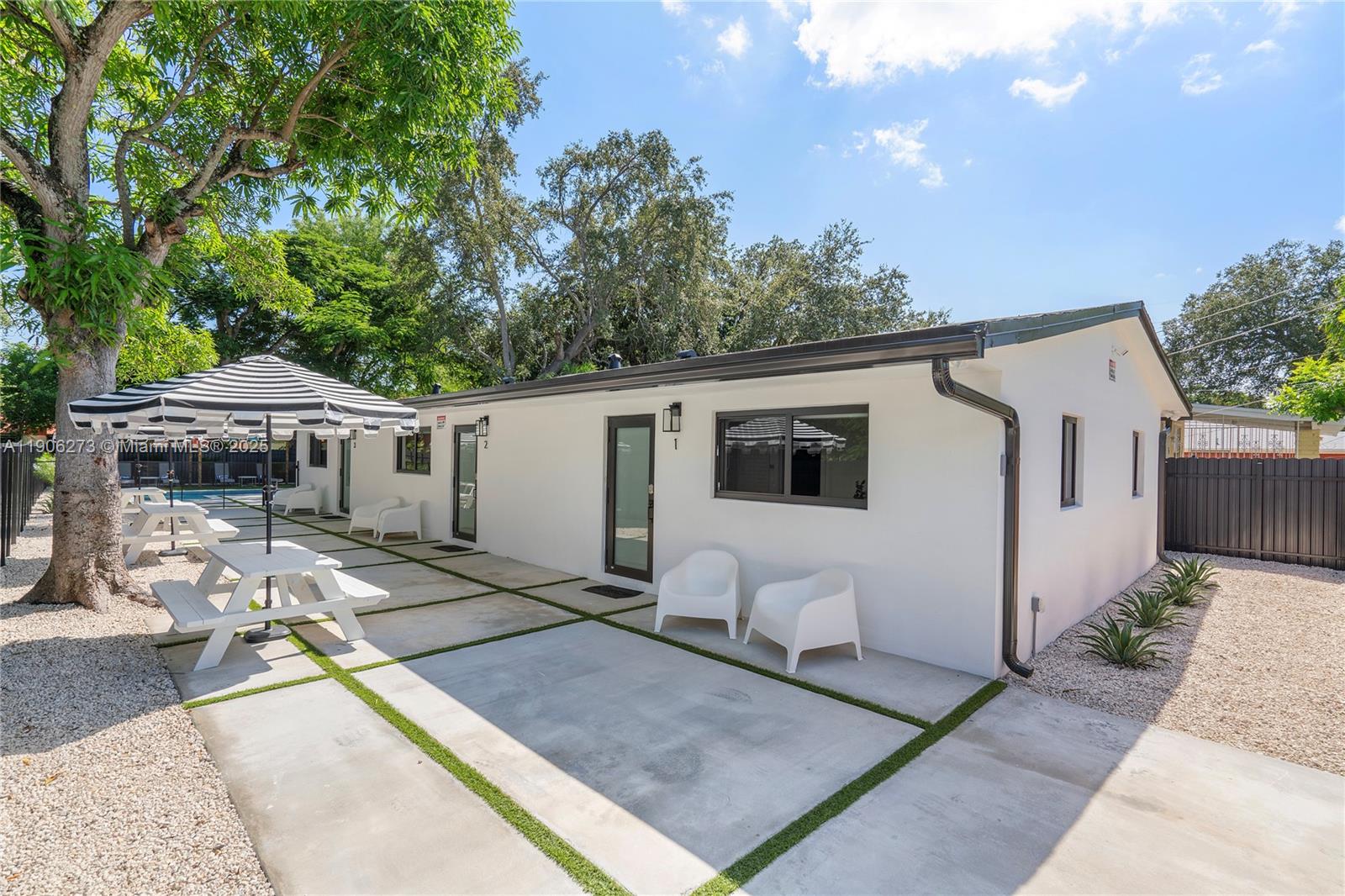 256 Northwest 57th Street Miami, FL 33127 - Photo 16 of 45 a front view of house with yard outdoor seating and covered with trees