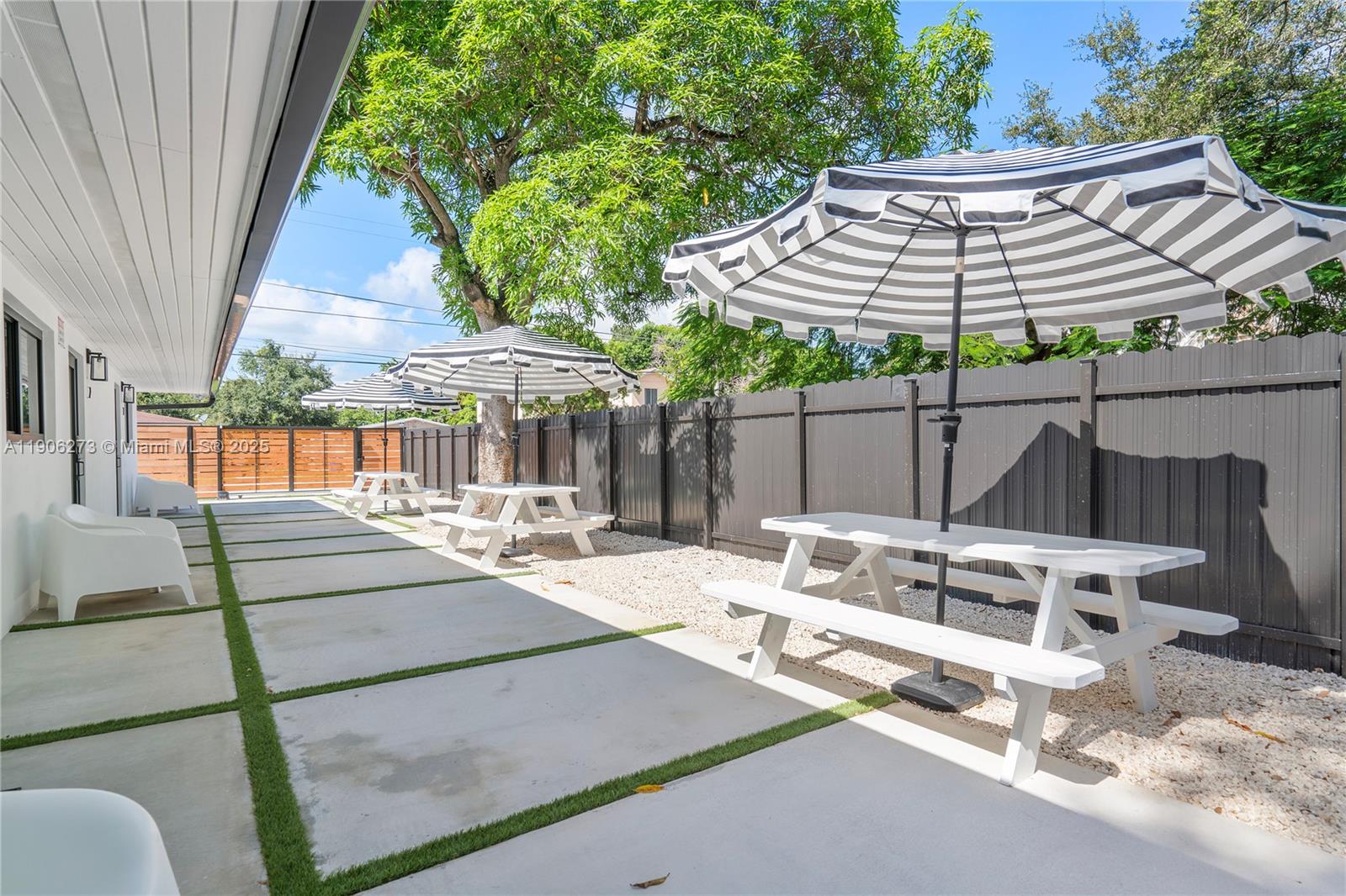 256 Northwest 57th Street Miami, FL 33127 - Photo 21 of 45 a patio with a table and chairs under an umbrella