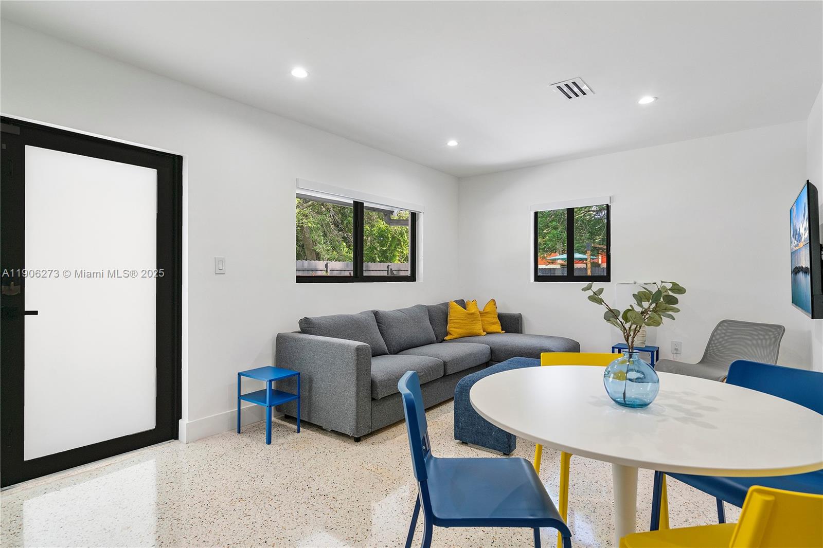 256 Northwest 57th Street Miami, FL 33127 - Photo 32 of 45 a living room with furniture a wooden floor and a potted plant