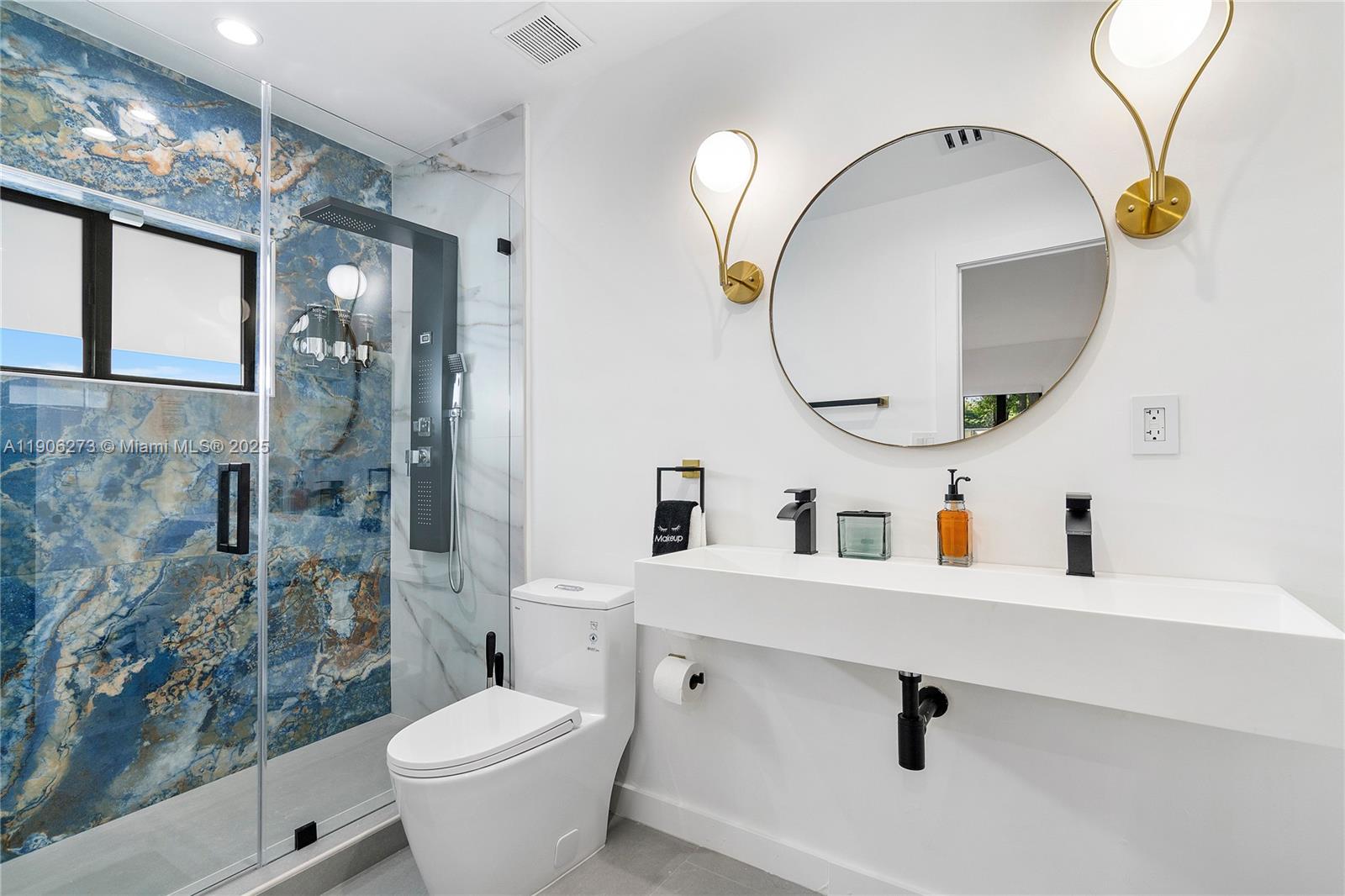 256 Northwest 57th Street Miami, FL 33127 - Photo 34 of 45 a bathroom with a toilet sink and mirror